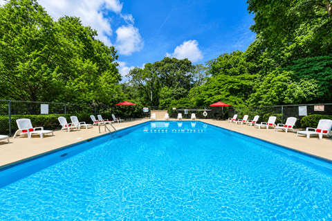 Swimming pool with lounge chairs and umbrellas at Stratford Arms Apartments, Riverdale, Georgia