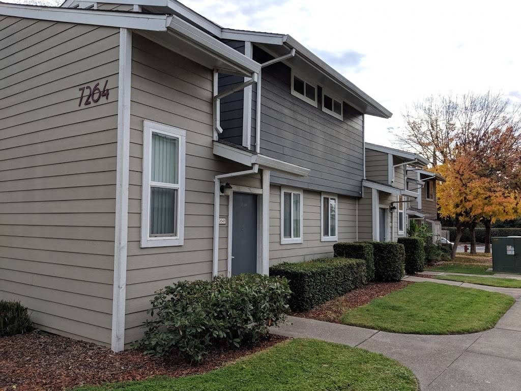 a row of houses with gray siding and a gray door