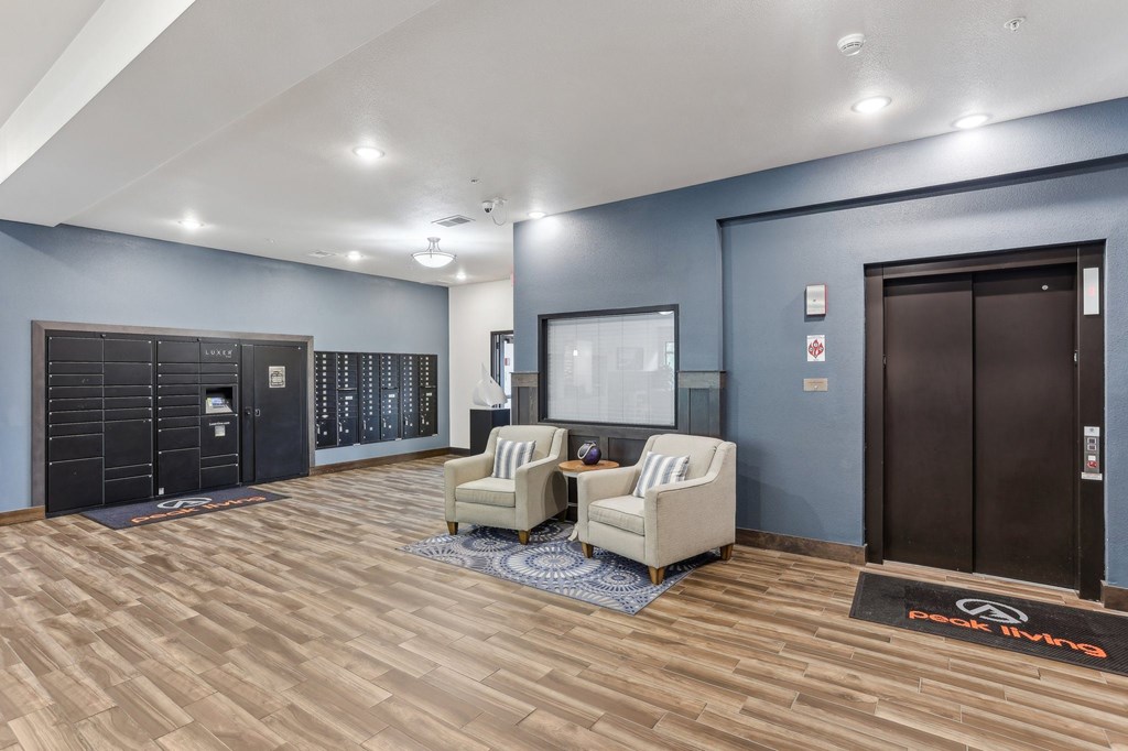 A room with a wooden floor and two chairs. at Lake Ridge Apartments, Prior Lake, MN