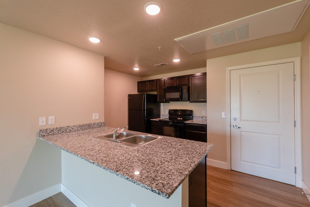 A kitchen with granite countertops and a sink.