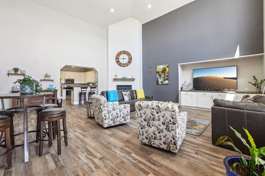 A living room with a grey couch and a white wall with a clock on it. at Stetson Meadows Apartments, Colorado Springs, 80922