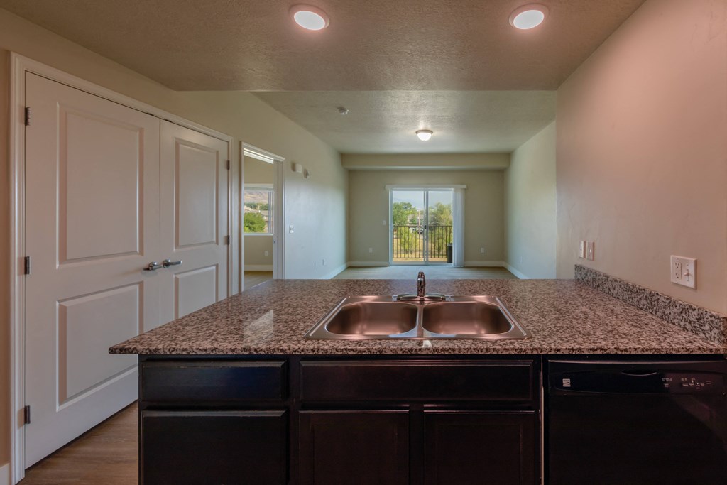 A kitchen with granite countertops and a double sink.