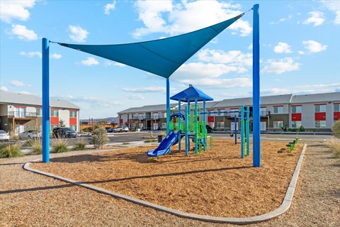 Childrens playground with shade sail and play equipment at Sunland Flats Apartments, Phoenix, AZ