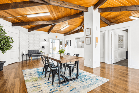 A dining room with a wooden table and chairs.