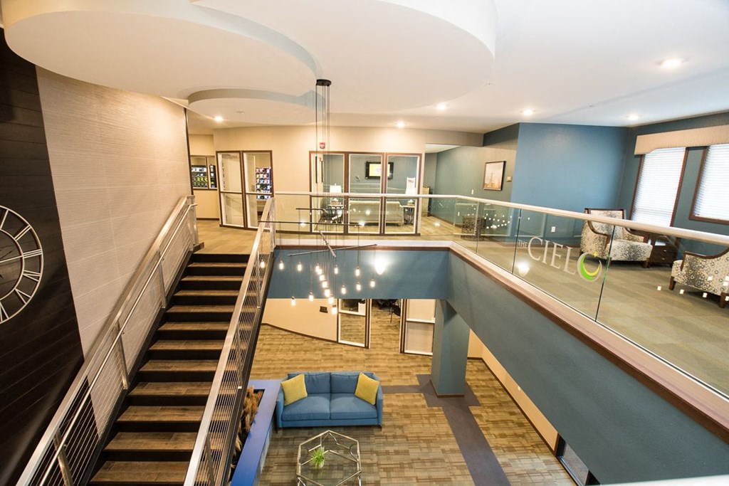 the lobby or reception area of a hotel with a glass staircase