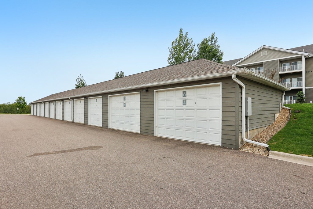 A long row of garage doors in front of a building. at Lake Ridge Apartments, Minnesota