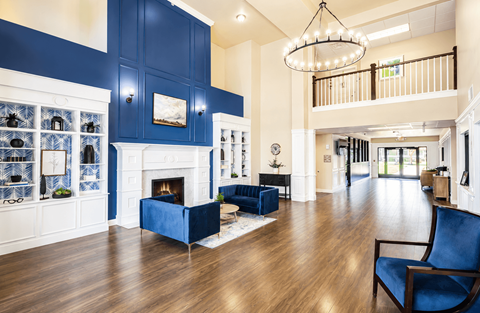 A blue and white living room with a fireplace and a blue chair.