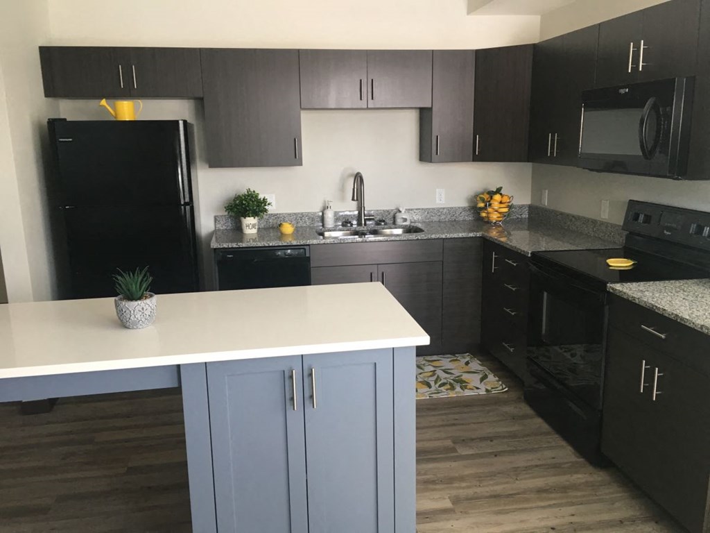 a kitchen with black cabinets and a white counter top