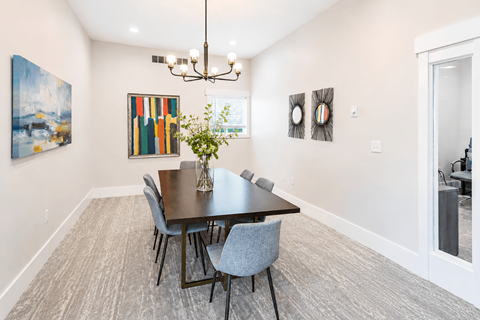 A dining room with a table and chairs.