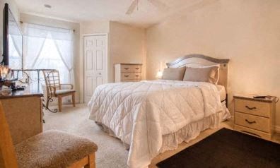 a bedroom with a bed and a dresser and a window