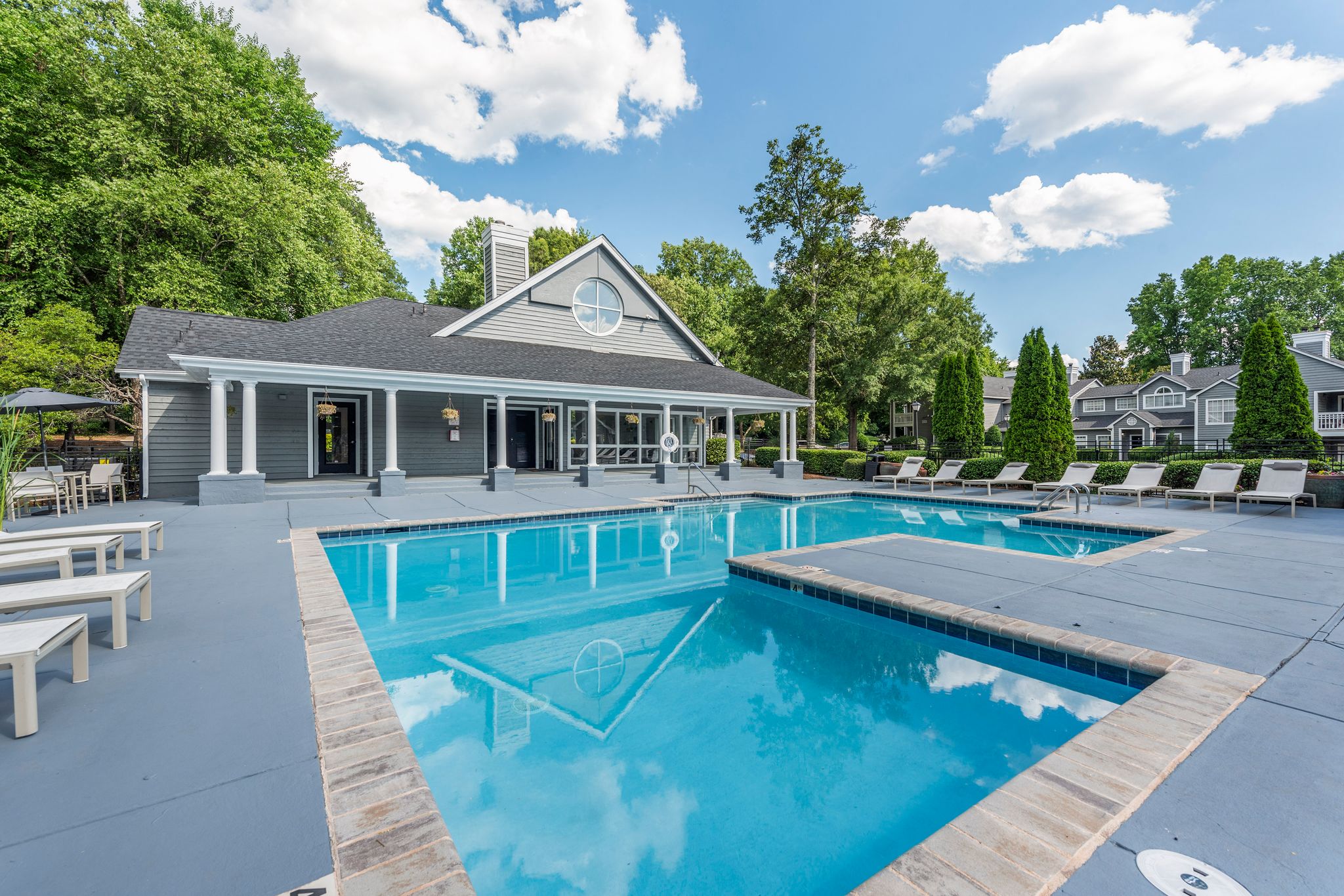 a swimming pool with a house in the background