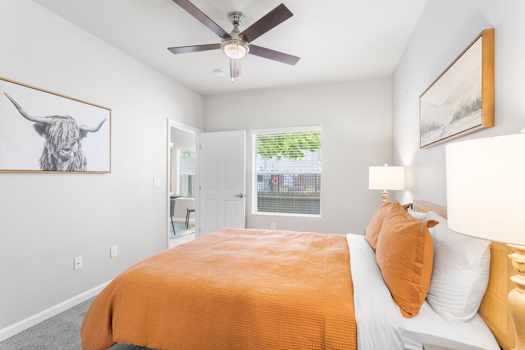 a bedroom with a bed and a ceiling fan