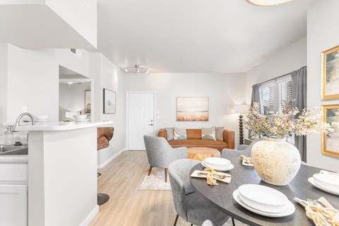 a living room and dining room with a table and chairs