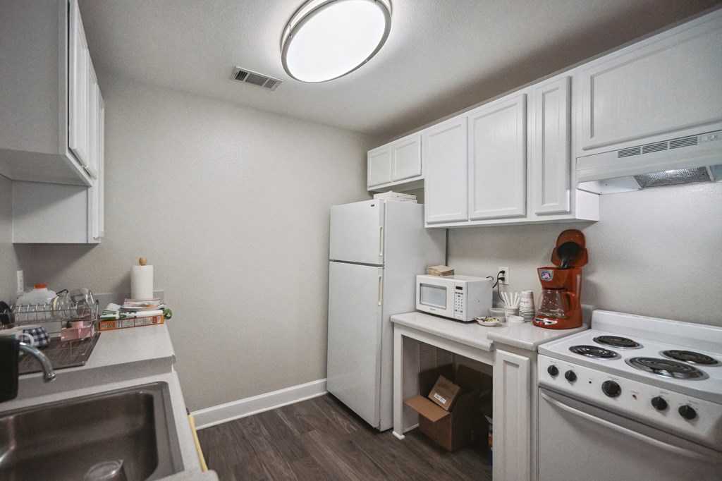 A small kitchen with white appliances and cabinets.