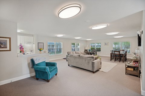 a living room with a couch and a chair and a dining room