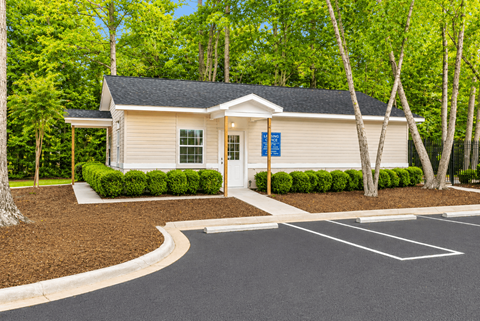 A small building with a parking lot in front of it.