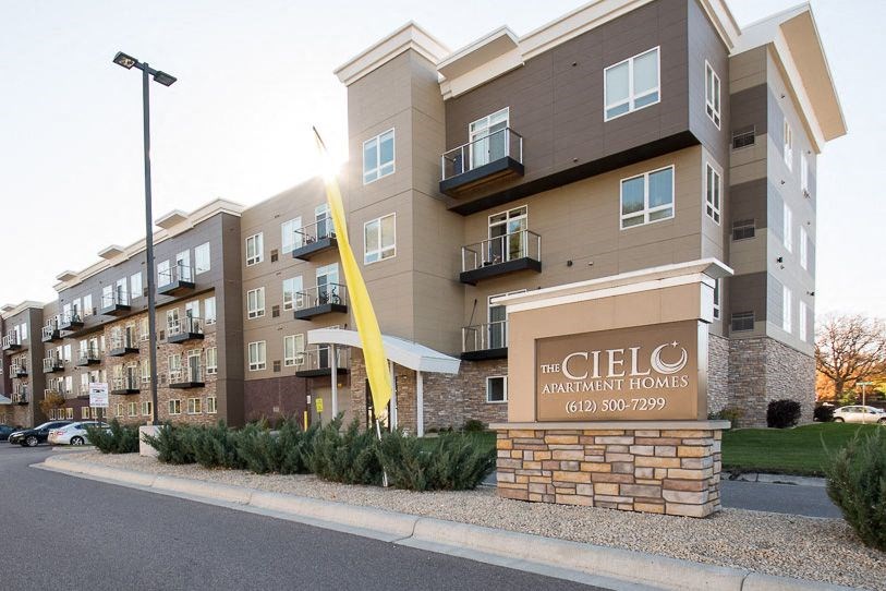 an apartment building with a sign in front of it