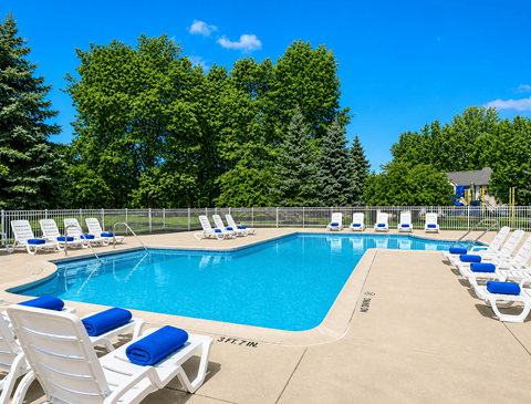 Outdoor swimming pool with lounge chairs and towels at Northview Park Apartments, Michigan