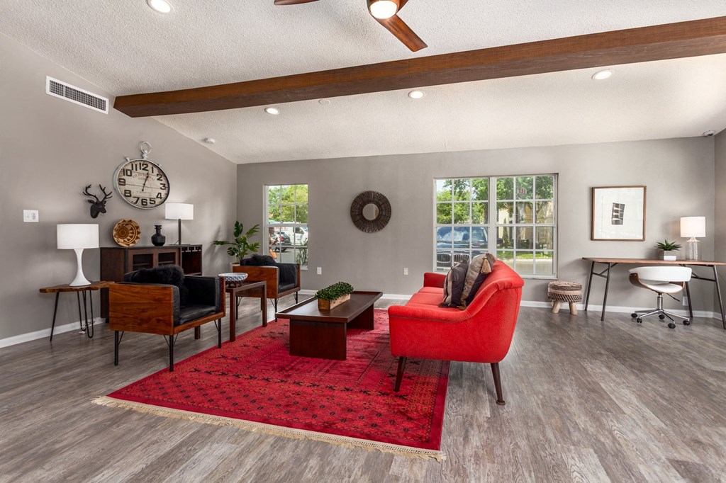 a living room with a red rug and furniture