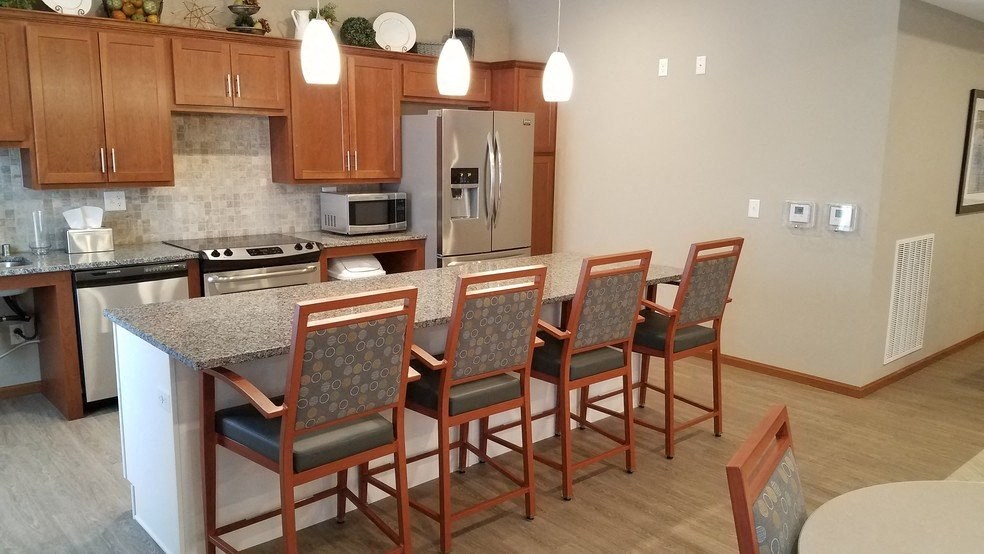 a kitchen with an island with chairs around it
