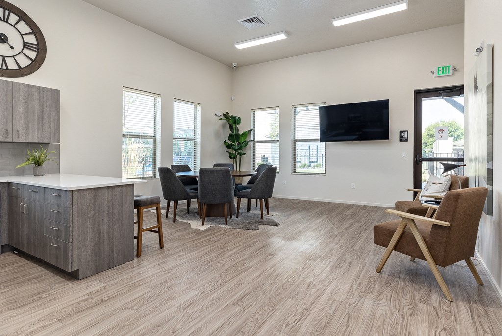 an open living room and dining area with a large clock on the wall and chairs