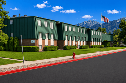 A green building with a flag on top and a red fire hydrant in front.