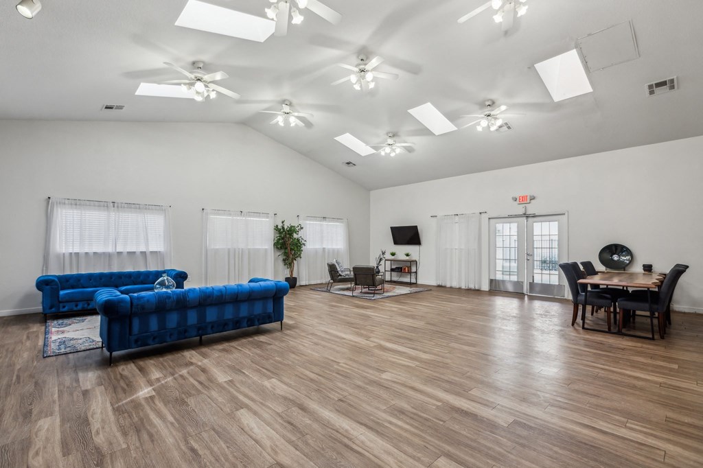 A living room with a blue couch and wooden floors.