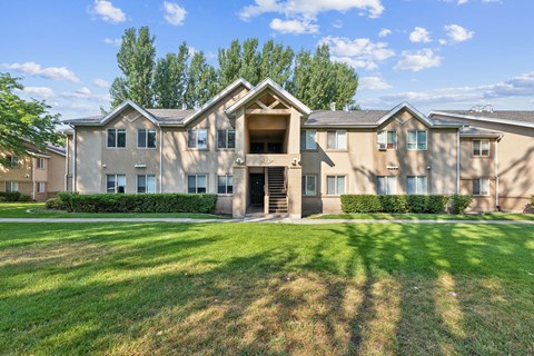 the view of an apartment building with a green lawn
