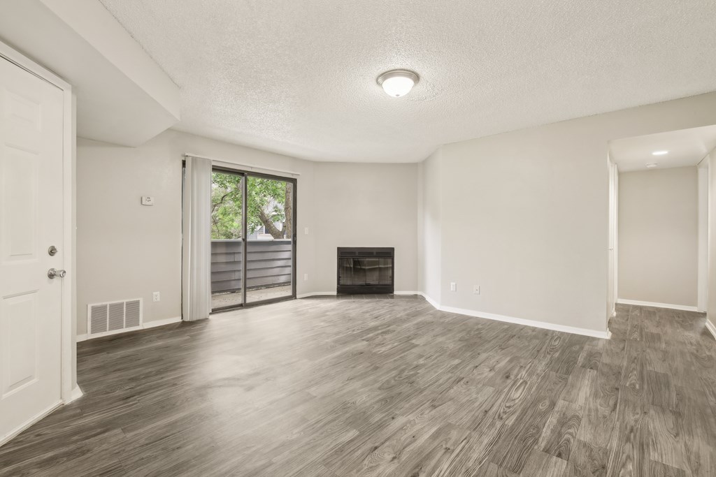 A spacious living room with a fireplace and sliding glass doors.