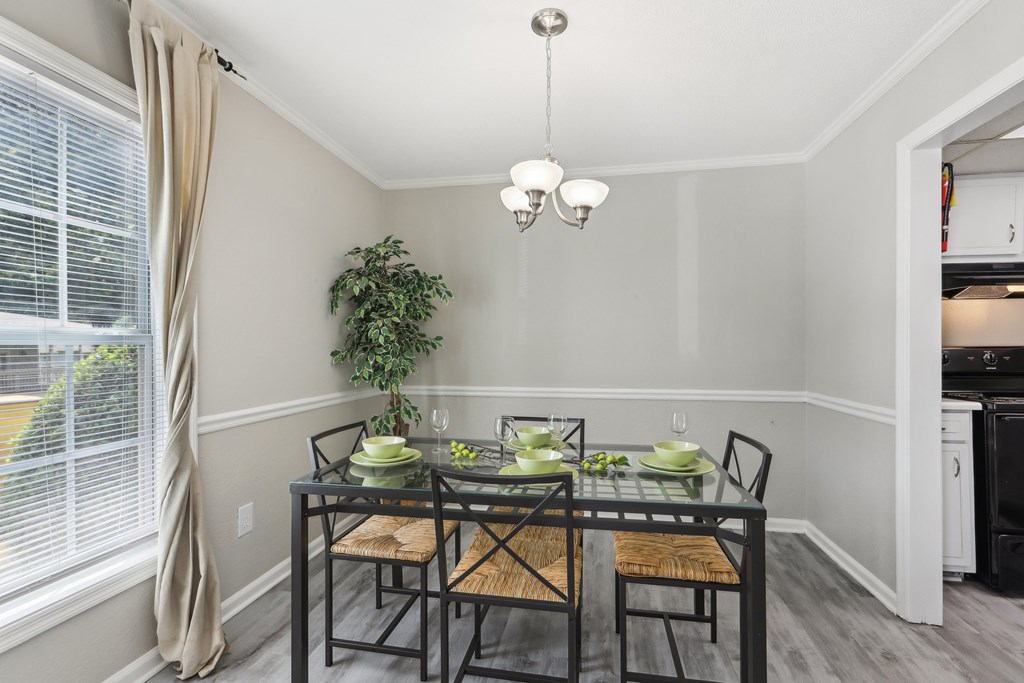 A dining room with a glass table and chairs.