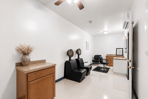 A living room with a black couch and a wooden cabinet.