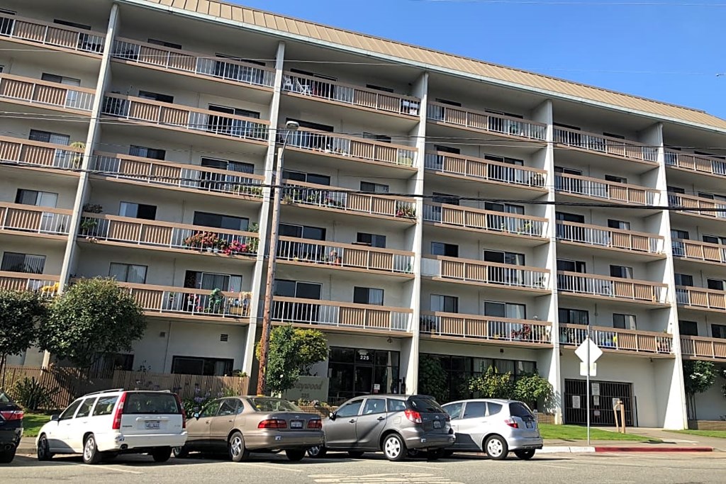 an image of an apartment building with cars parked in front