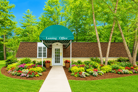 A green Leasing Office building with a white walkway leading to the entrance.