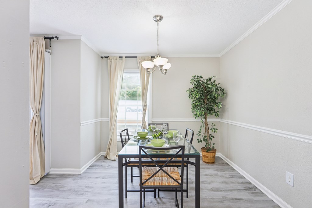 A dining room with a table set for four.