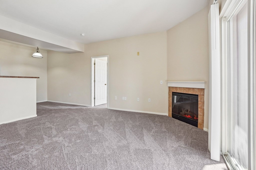 A living room with a fireplace and a grey carpet. at Stetson Meadows Apartments, Colorado Springs, 80922