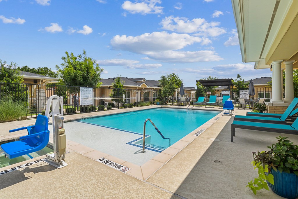 our apartments have a swimming pool with blue chairs