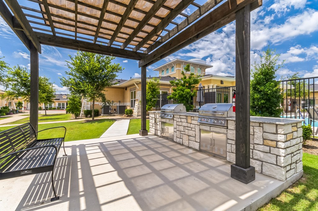 the preserve at ballantyne commons clubhouse with a grill and a patio with benches