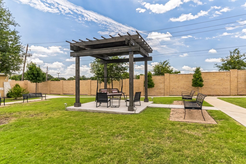 a patio with a picnic table and a gazebo