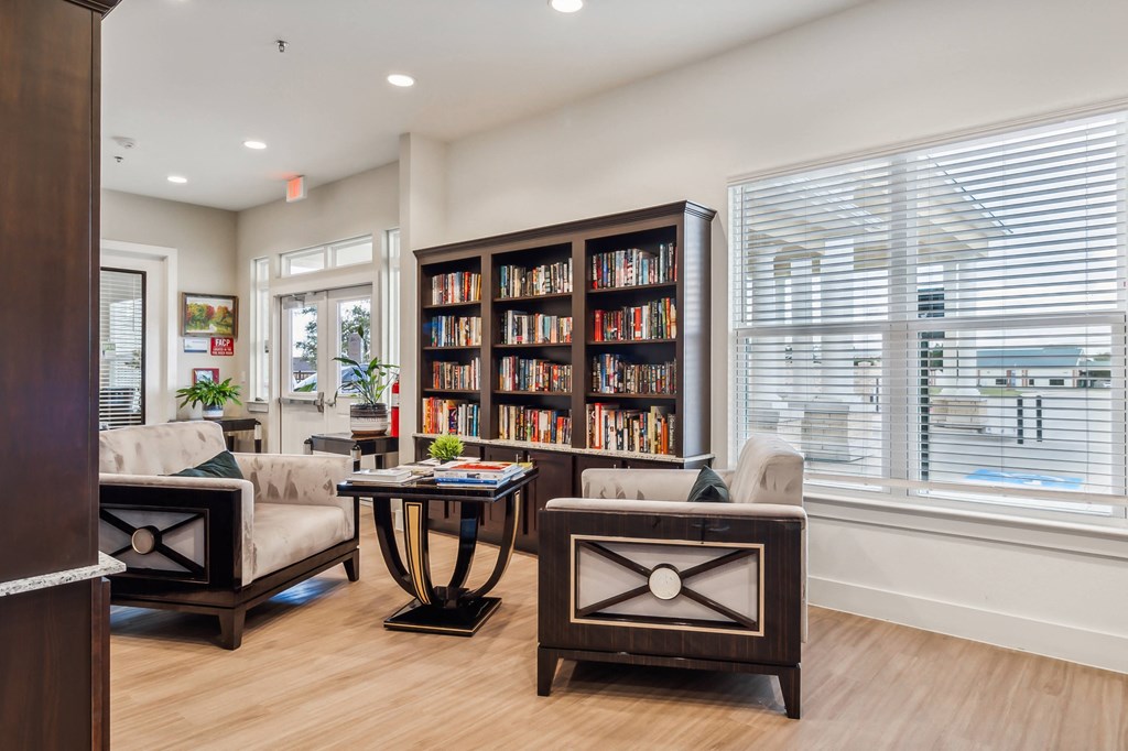 a living room with couches and chairs and a bookshelf filled with books