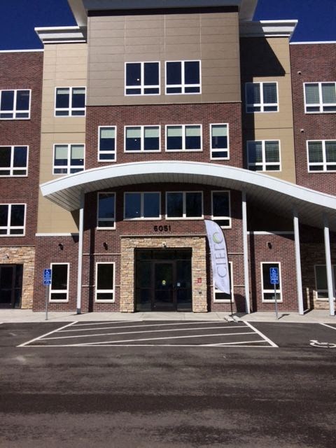 the front of a building with a parking lot