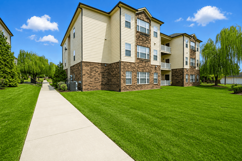 Apartment building with a concrete walkway in front.