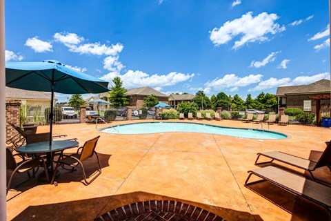 our apartments have a large pool and patio with chairs and umbrellas