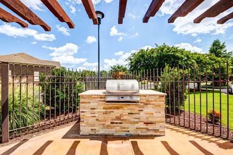 the backyard has a grill and a barbecue area with a fence