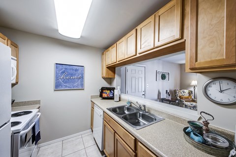 a kitchen with a sink and a stove and a clock
