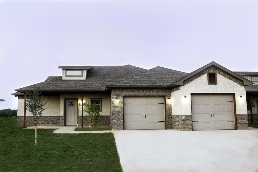 a house with two garage doors and a lawn
