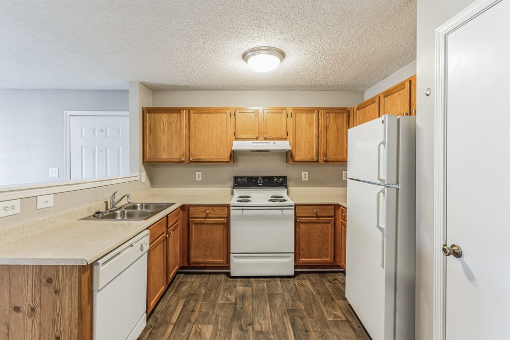 a kitchen with white appliances and wooden cabinets