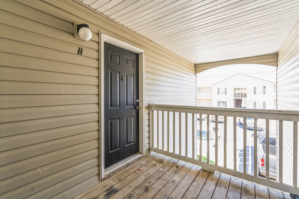 the front porch of a house with a black door