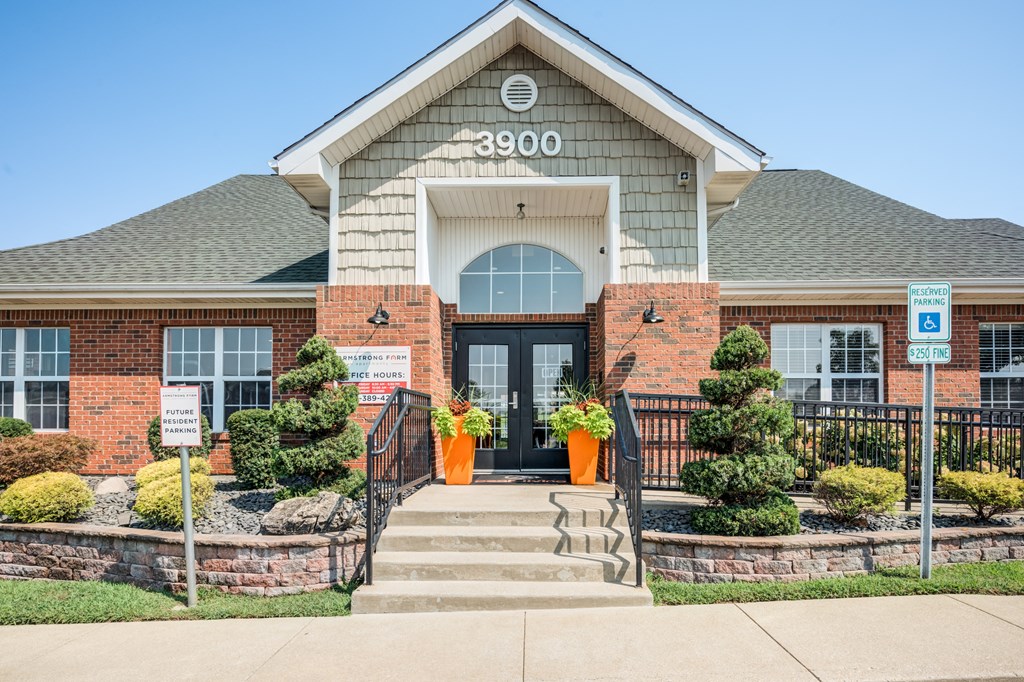 the front of a building with stairs and a black gate
