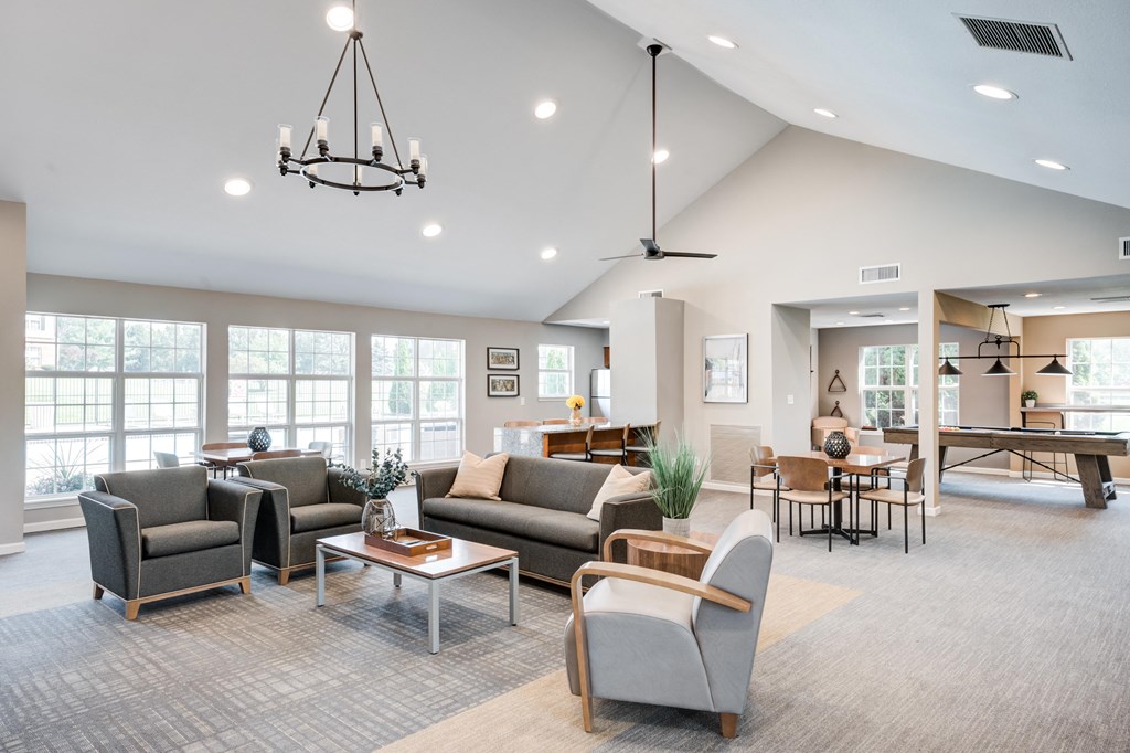 a living room with couches and chairs and a dining room with a table