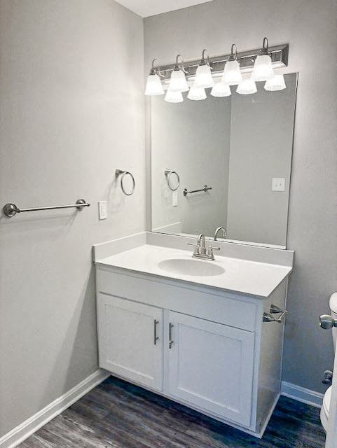 A white bathroom vanity with a mirror and lights above it.